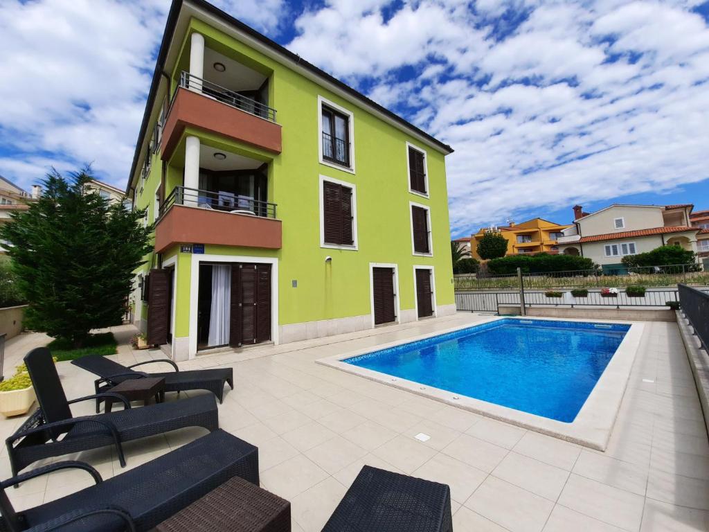 una casa con piscina al lado de un edificio en Smaragdna Villa YourCroatiaHoliday, en Premantura