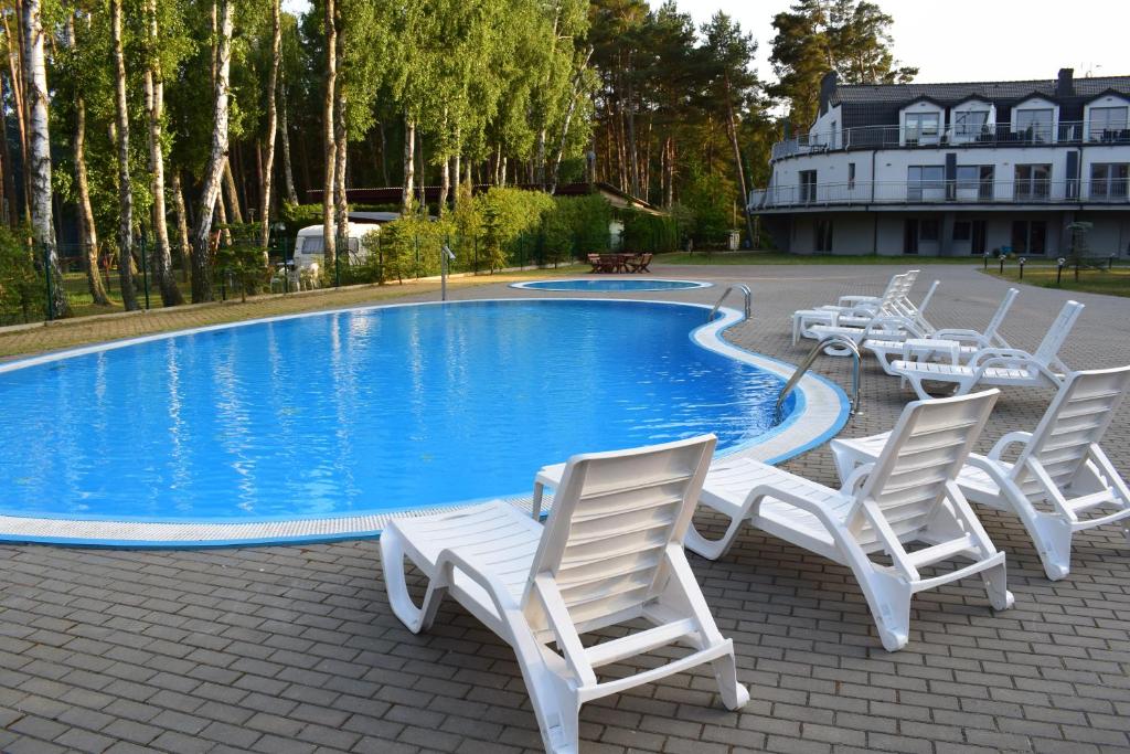 un gruppo di sedie intorno alla piscina di Apartament Silence Baltic White a Pobierowo
