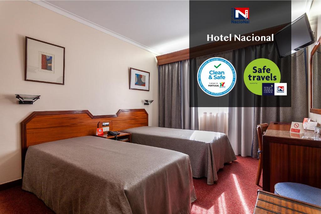 リスボンにあるホテル ナシオナルのベッド2台と看板が備わるホテルルームです。