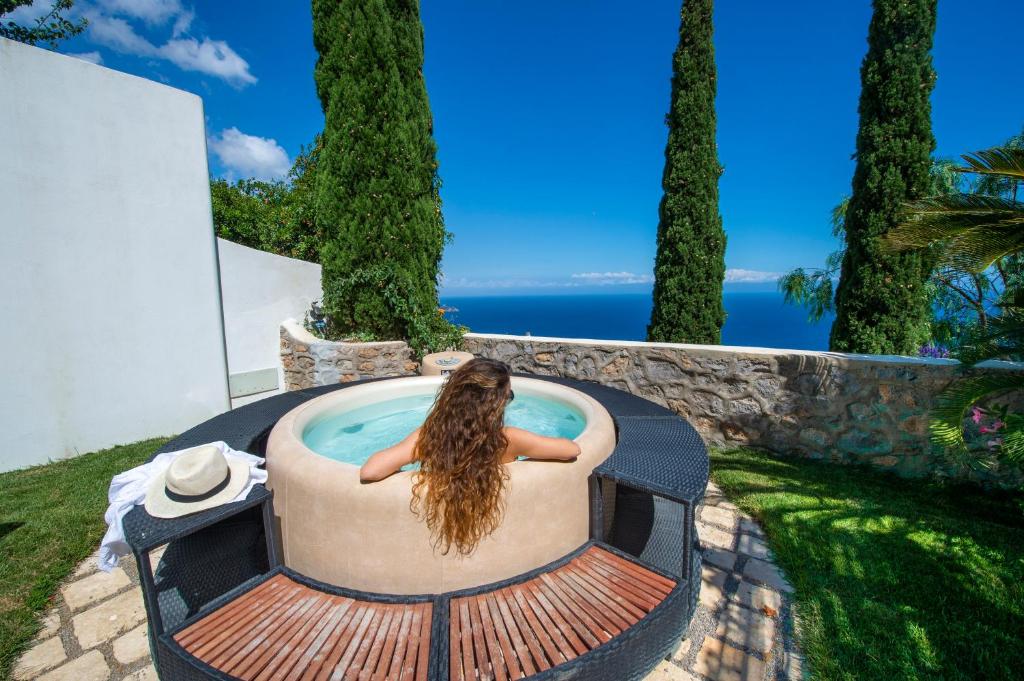 a woman sitting in a hot tub with the view of the ocean at Casa Elena in Praiano