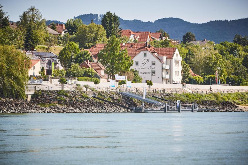 widok na rzekę z domami i miastem w obiekcie Hotel Donauhof w mieście Emmersdorf an der Donau