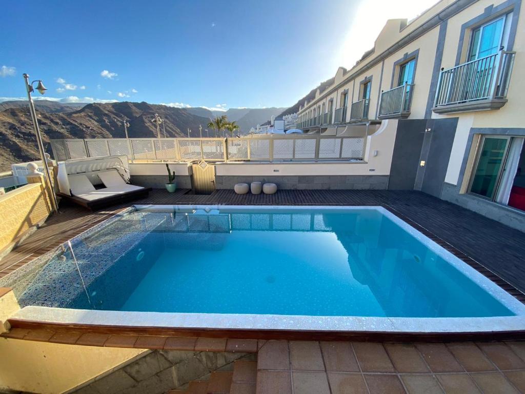 una piscina nel cortile di un edificio di Villa Happy Dreamer a Puerto Rico de Gran Canaria