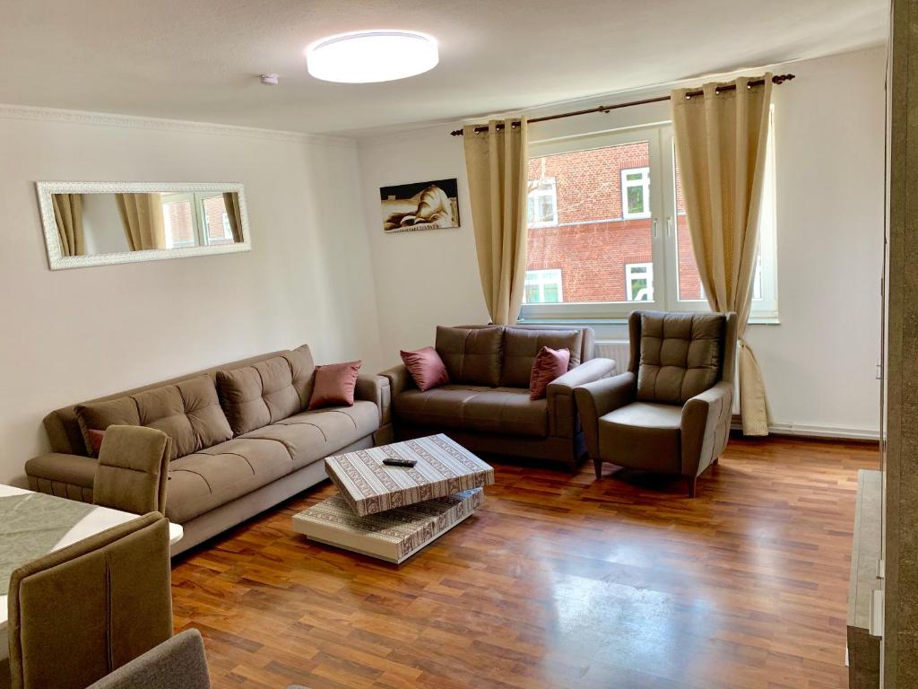 ein Wohnzimmer mit einem Sofa und 2 Stühlen in der Unterkunft Classic Kian in Hannover
