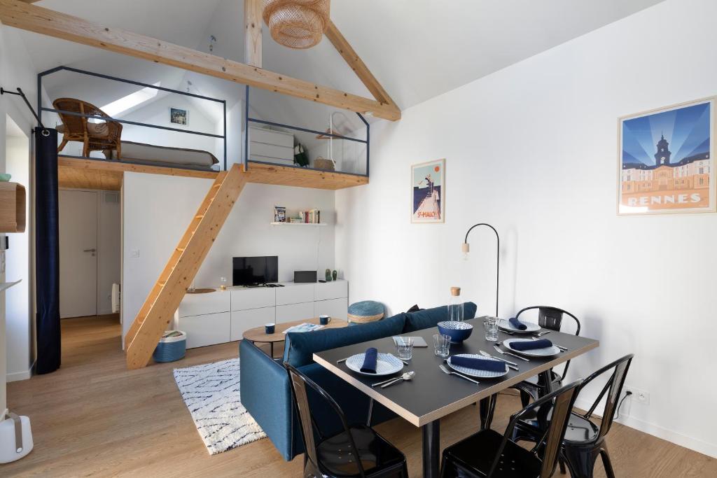 uma sala de jantar e sala de estar com uma cama alta em LA DEROBEE - Havre de paix en ville em Rennes