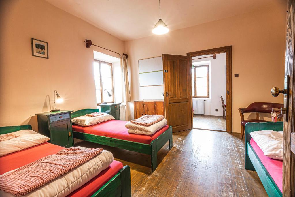 1 dormitorio con 2 camas y puerta con ventana en Hostel 99, en Český Krumlov