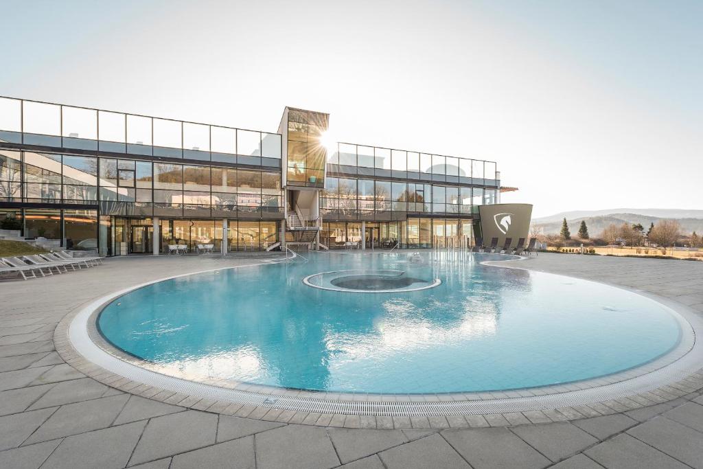 a large swimming pool in front of a building at Hotel und Therme NOVA in Köflach