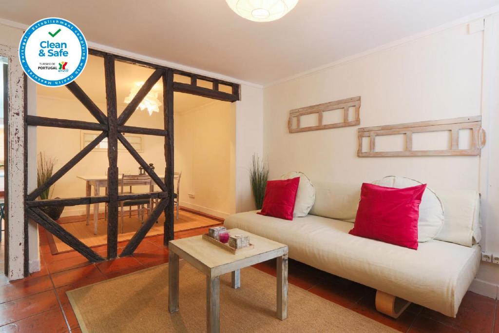 sala de estar con sofá blanco y almohadas rojas en Santo António Apartment, en Lisboa