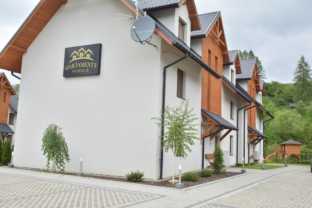a building with a sign on the side of it at Apartamenty Homole in Szczawnica