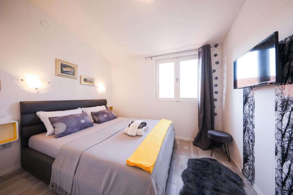 um quarto com uma cama grande e uma televisão em Apartment Rita em Zadar