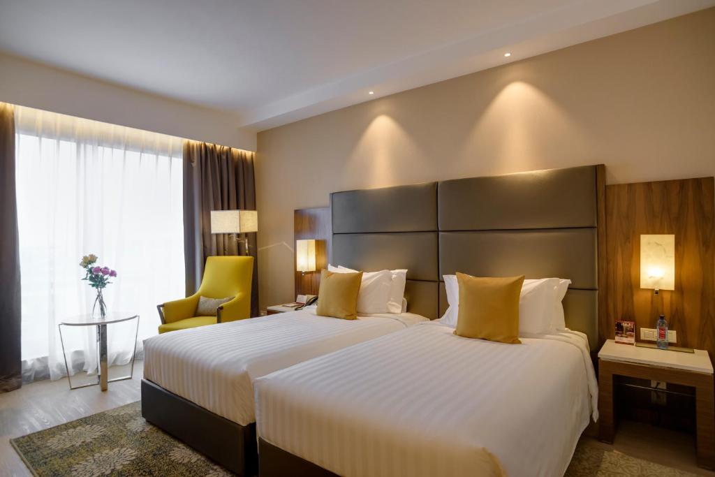 a hotel room with a large bed with yellow pillows at Crowne Plaza Nairobi Airport by IHG in Nairobi