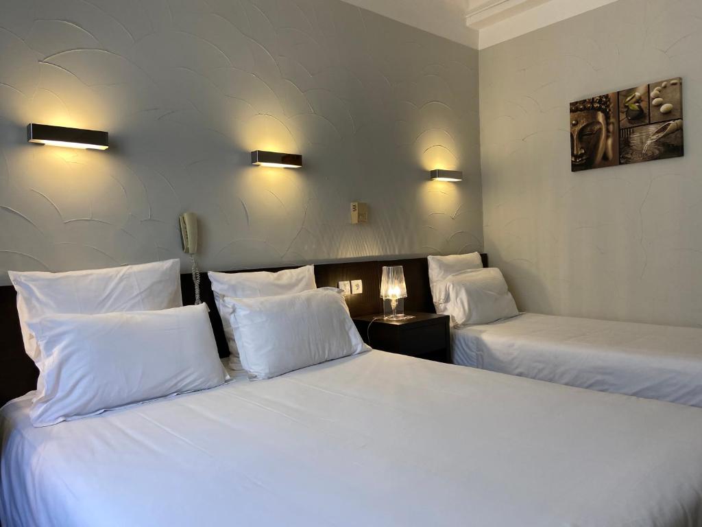 Postel nebo postele na pokoji v ubytování Hôtel Neptune