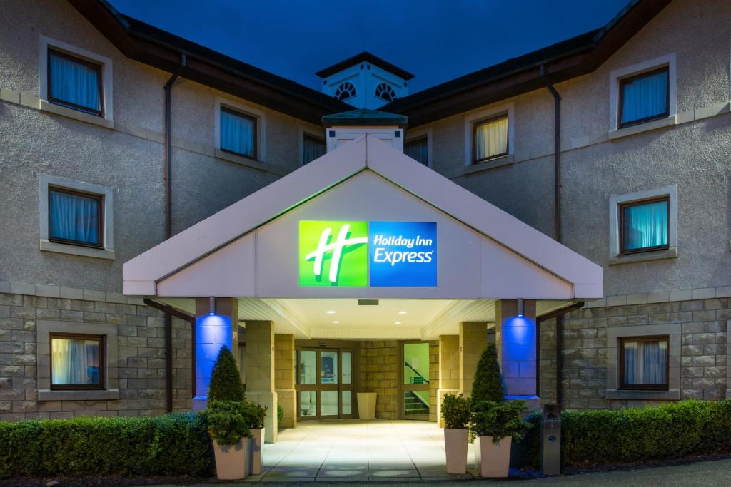 a hotel with a sign on the front of a building at Holiday Inn Express Inverness by IHG in Inverness