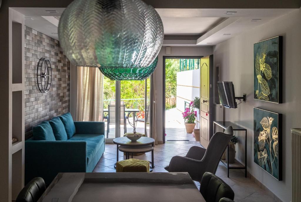 a living room with a blue couch and a glass chandelier at Ifigeneia apartment in Alepou