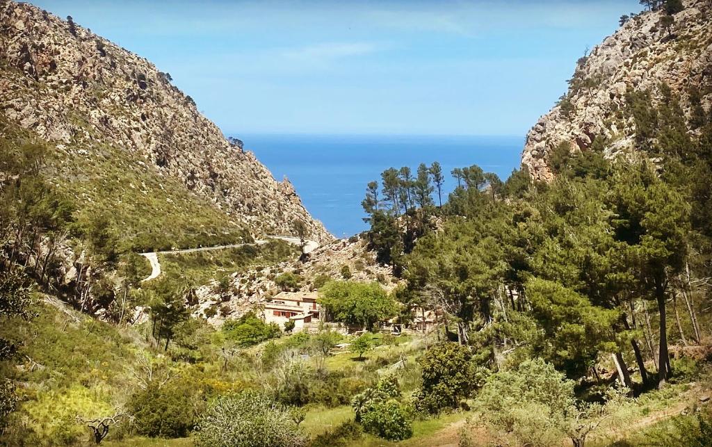 un villaggio in montagna con l'oceano sullo sfondo di Finca Ses Fontanelles a Andratx