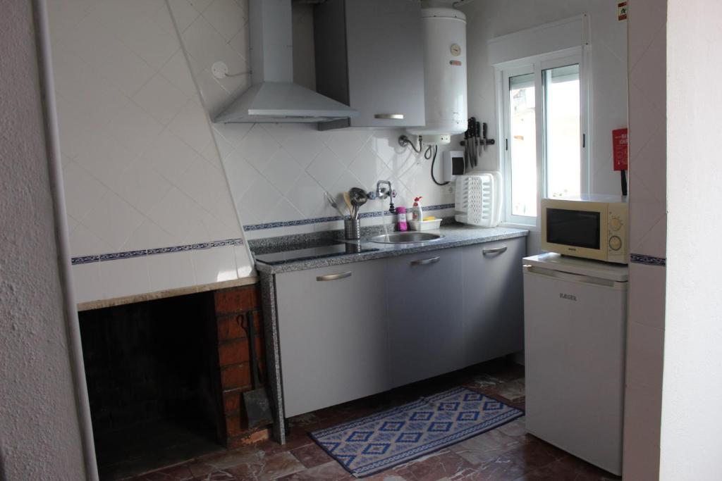a small kitchen with a sink and a microwave at Casa Avô T1 in Avô