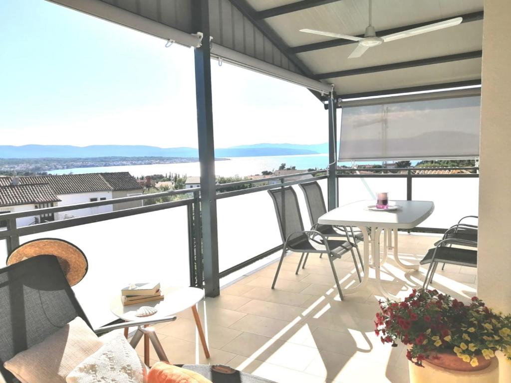 a balcony with a table and chairs and a view of the ocean at Lovely Sea View House in Malinska Island Krk in Malinska