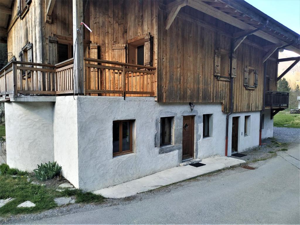 a building with a deck on the side of it at Appartement dans ferme rénovée au cœur du Grand Massif in Sixt