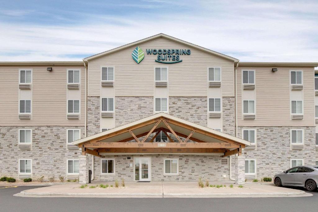 ein großes Gebäude mit einem Schild darüber in der Unterkunft WoodSpring Suites Carol Stream - Chicago in Carol Stream