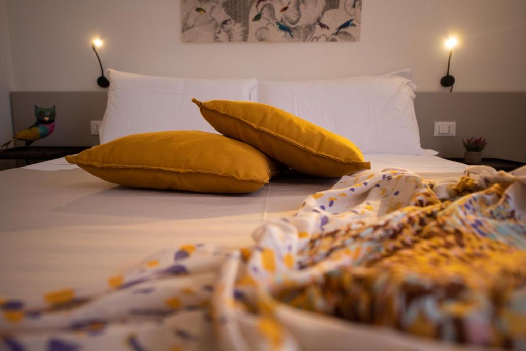 a bed with two yellow pillows on top of it at San Vito Accommodations in San Vito lo Capo