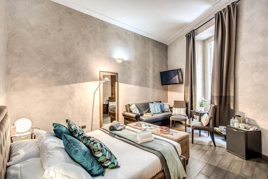 ローマにあるLa Residenza Dell'Angeloのベッドとリビングルームが備わるホテルルームです。