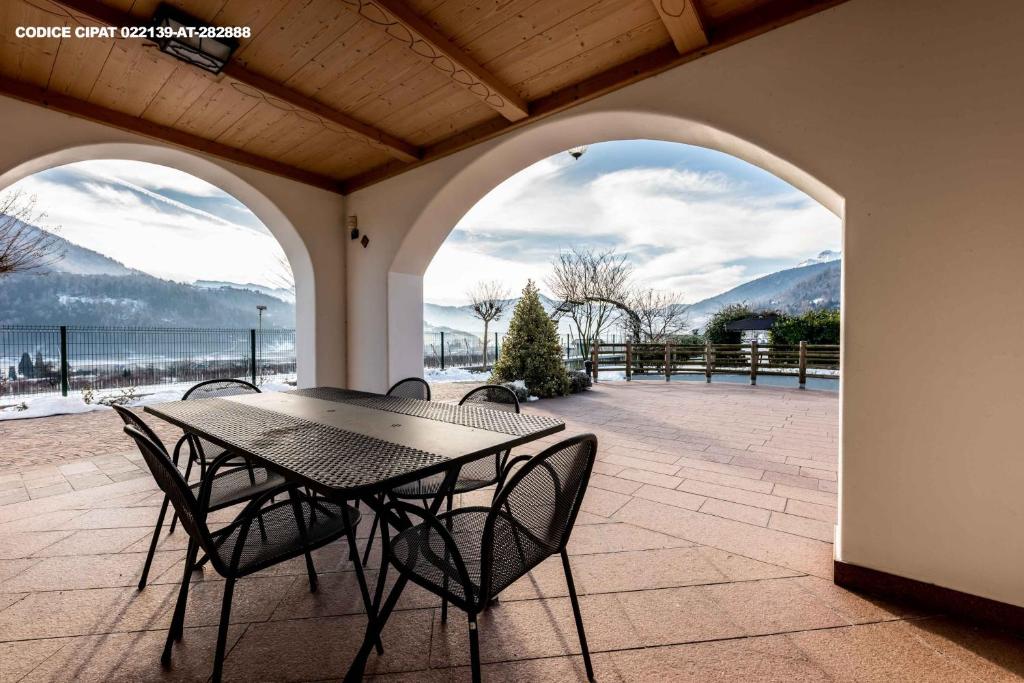 una mesa y sillas en un patio con vistas al océano en Il Gallo, en Pergine Valsugana