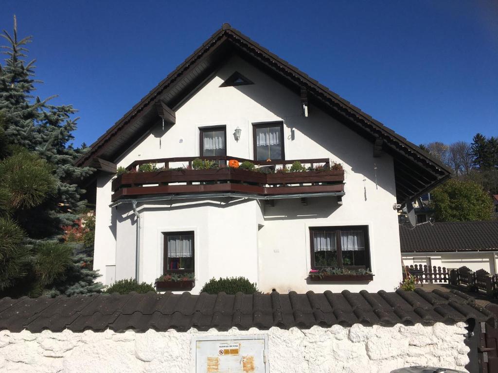 a white house with windows and a balcony at Penzion U Ryglů in Vrchlabí