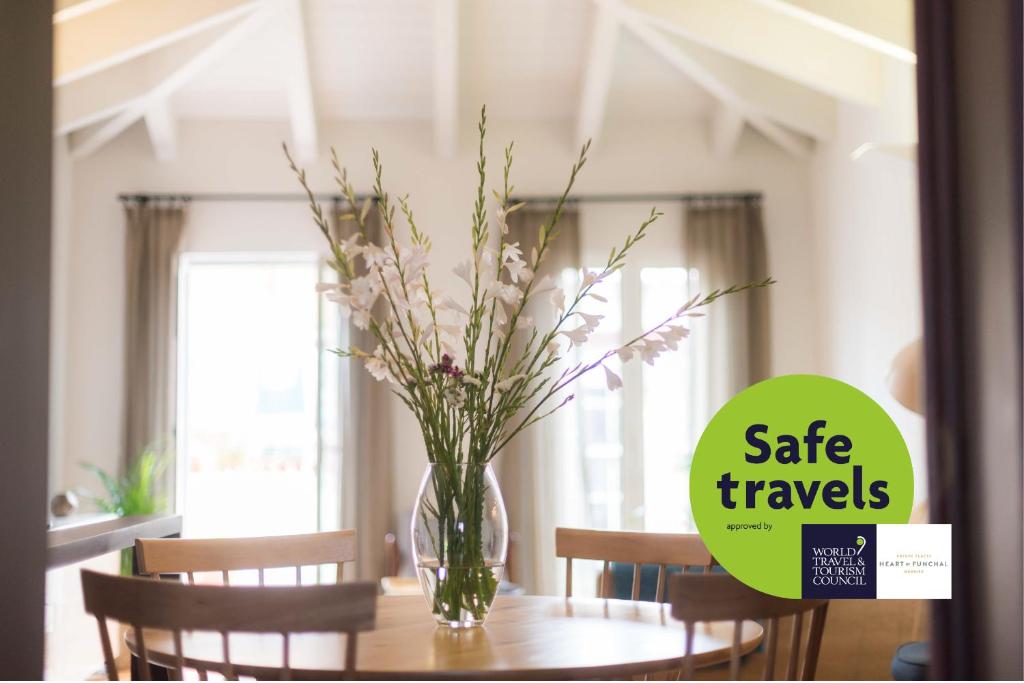 a vase of flowers on a table in a dining room at Apartamentos Santa Maria by Heart of Funchal in Funchal