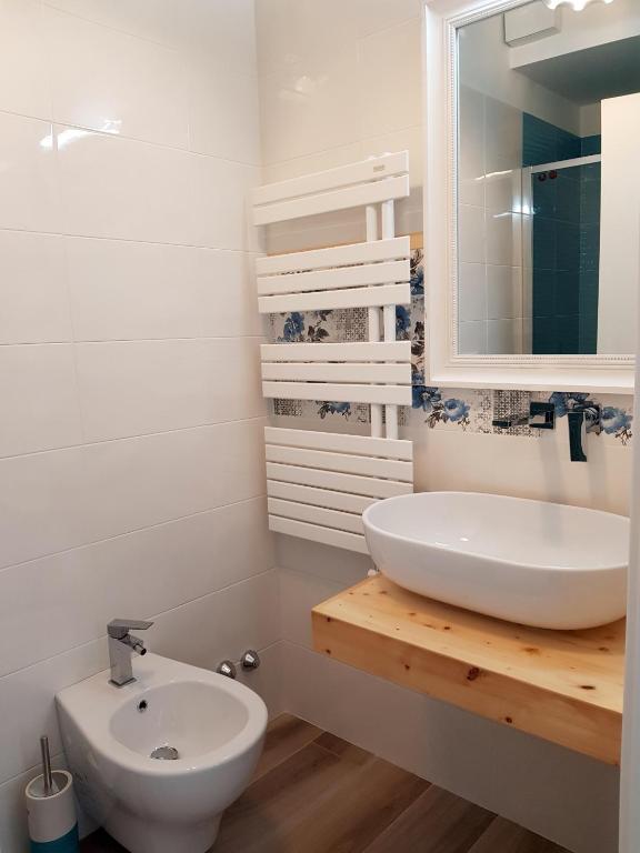a bathroom with a sink and a toilet and a mirror at RosAmar in Bari