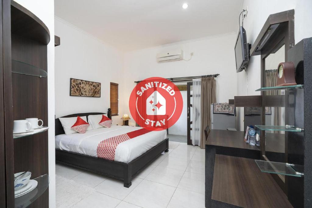 a bedroom with a bed with a red sign on it at OYO 2417 Panen House in Seminyak