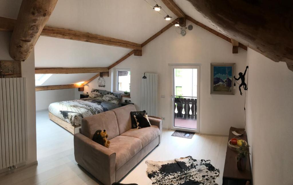 salon z kanapą i łóżkiem w obiekcie The Bijoux - Dolomites w mieście Agordo