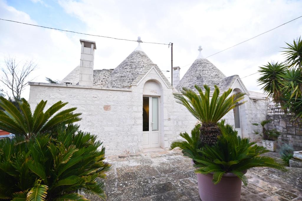 biały dom z palmami przed nim w obiekcie Agriturismo il Ciliegeto w mieście Locorotondo