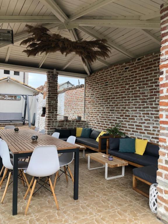 un patio avec des canapés et des tables ainsi qu'un mur en briques dans l'établissement Casa Mediterana, à 2 Mai