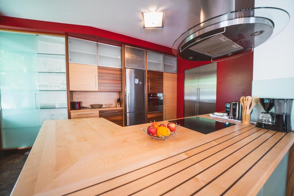 eine Küche mit einer Schale Obst auf einem Holztisch in der Unterkunft Dolomitenmannapartments in Lienz