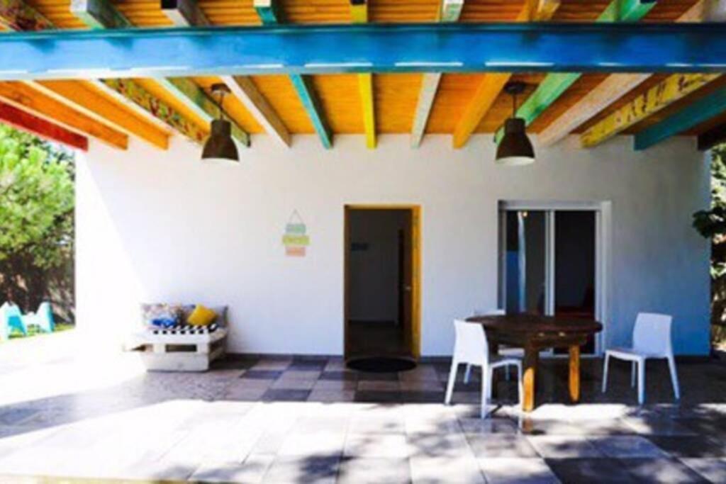 un patio con mesa, sillas y techo en Jacaranda Home, en Vejer de la Frontera