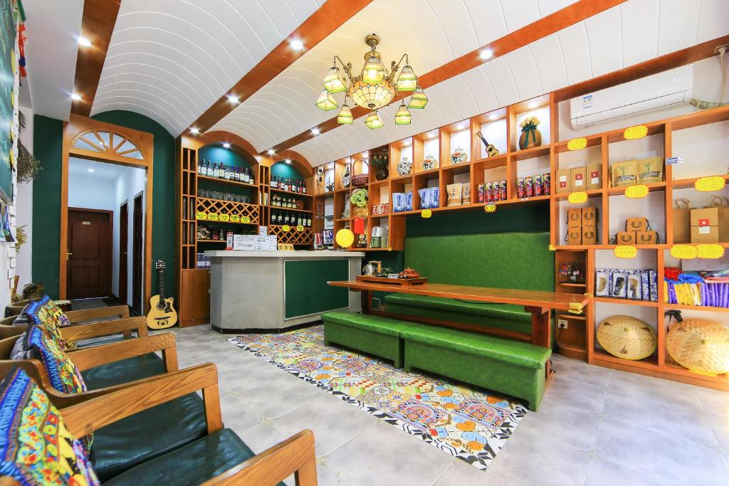 a shop with a green bench and chairs in a room at Edinburgh Hostel in Zhangjiajie