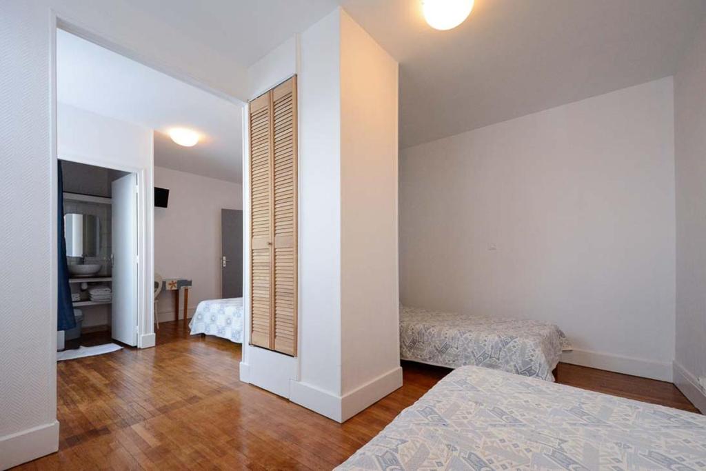 a room with two beds and a mirror in it at HOTEL DE LA POMME D'OR in Bar-sur-Aube