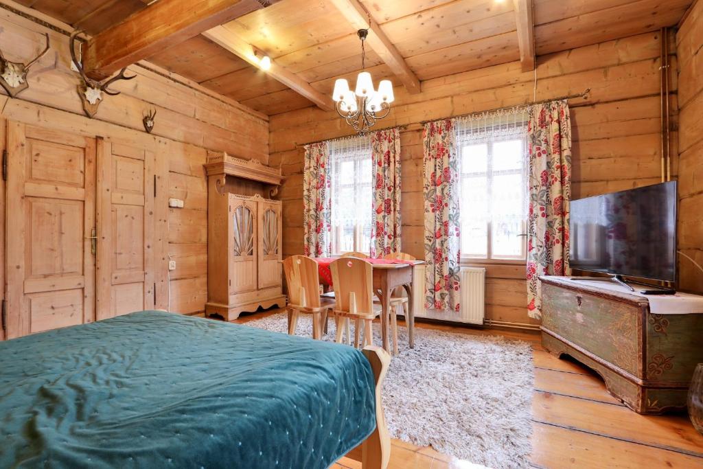 Un dormitorio con una cama, una mesa y un televisor. en Dom Tomusik, en Zakopane