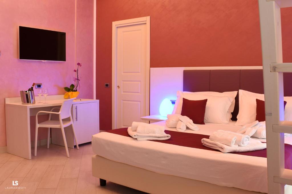 1 dormitorio con cama, escritorio, cama y mesa en Hotel Riviera Azzurra, en Oliveri