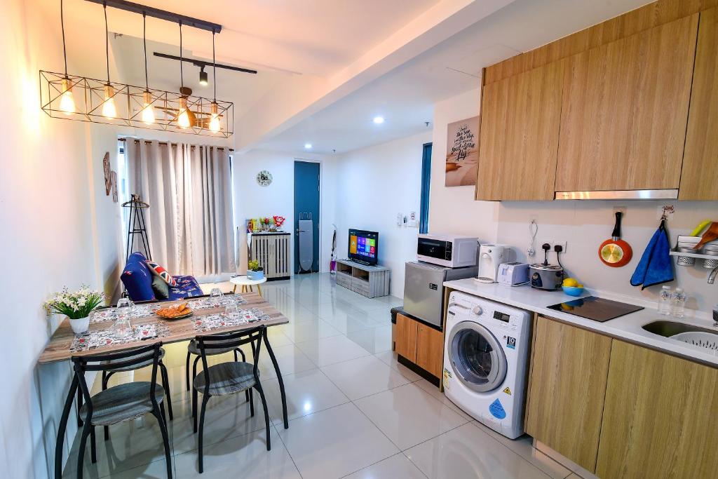 a kitchen with a washing machine and a table with chairs at Tropicana 218 Georgetown #31 無敵海景 一房一廳式Max.6pax in George Town
