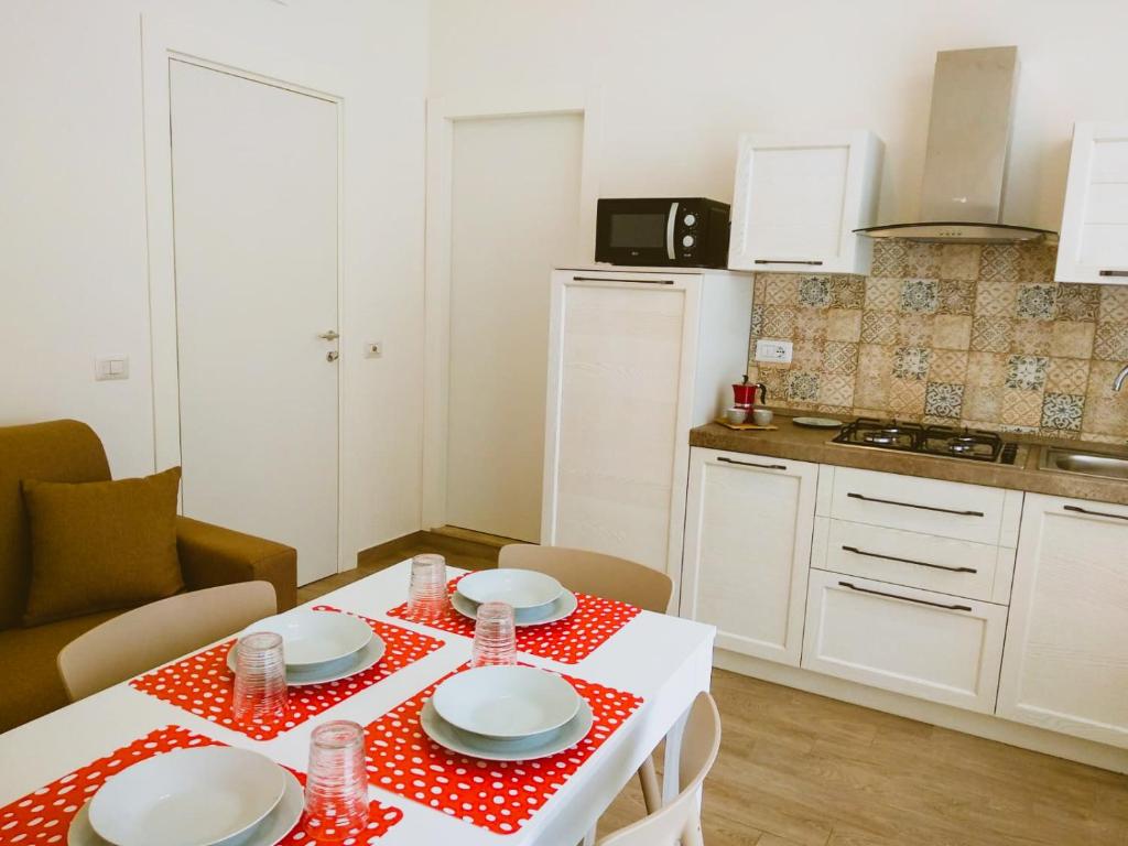 een keuken met een tafel met een rode en witte tafeldoek bij Le Tre Casuzze in Siracusa