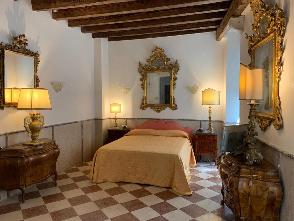 um quarto com uma cama, 2 candeeiros e um espelho em Luxury Apartment in San Marco with Canal View em Veneza