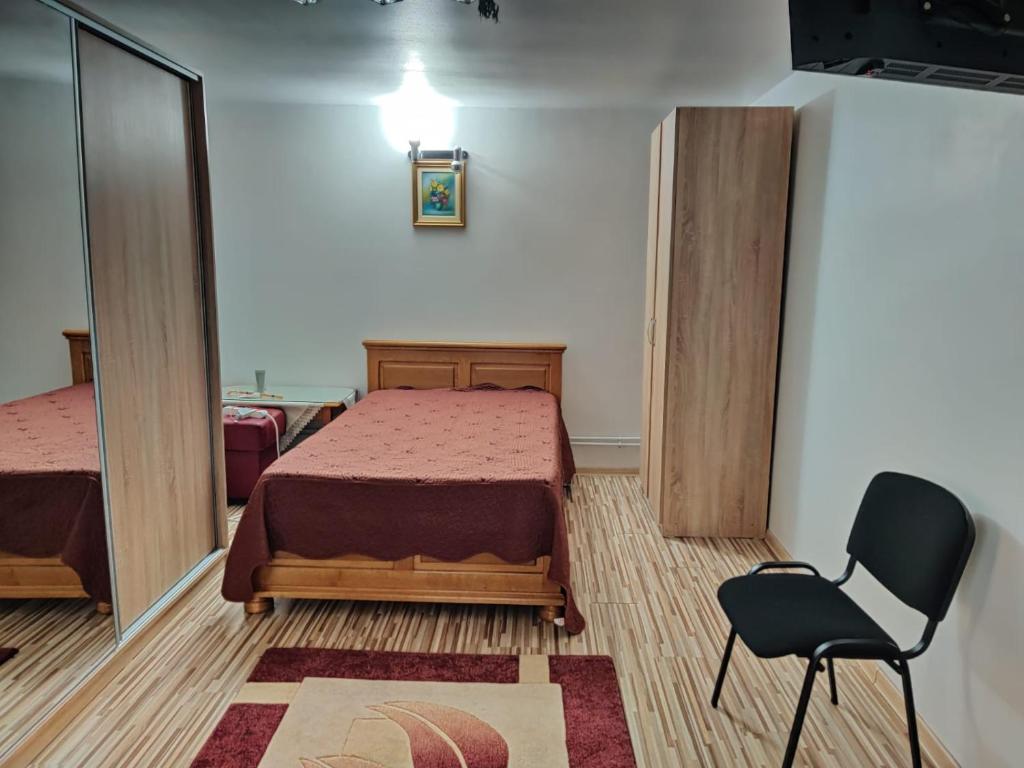 - une chambre avec un lit et une chaise dans l'établissement Cazare Buzău, à Buzău