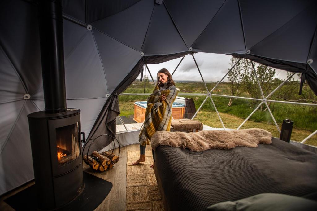 a woman standing inside of a tent with a stove at Reykjavik Domes in Reykjavík