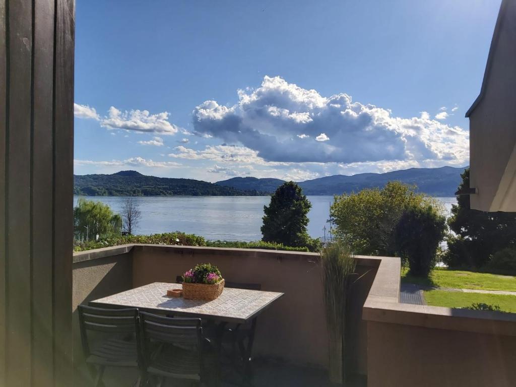 een tafel op een balkon met uitzicht op een meer bij Bnbook - La casa sul Lago Maggiore in Ispra