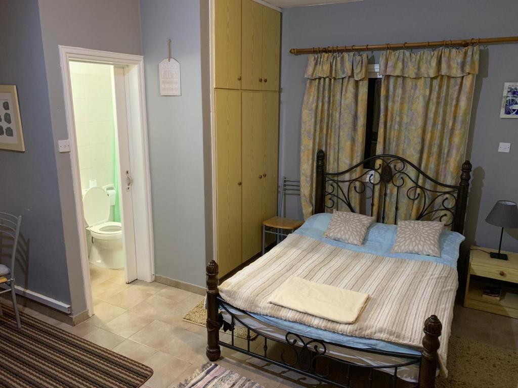 a bedroom with a bed and a bathroom with a toilet at Detached Cozy Studio in Paralimni