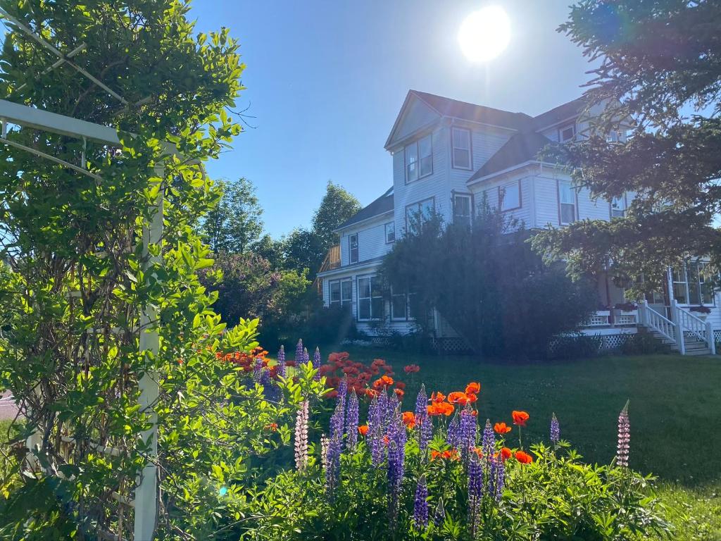 a house with a garden of flowers in front of it at Harbourview Inn in Smiths Cove