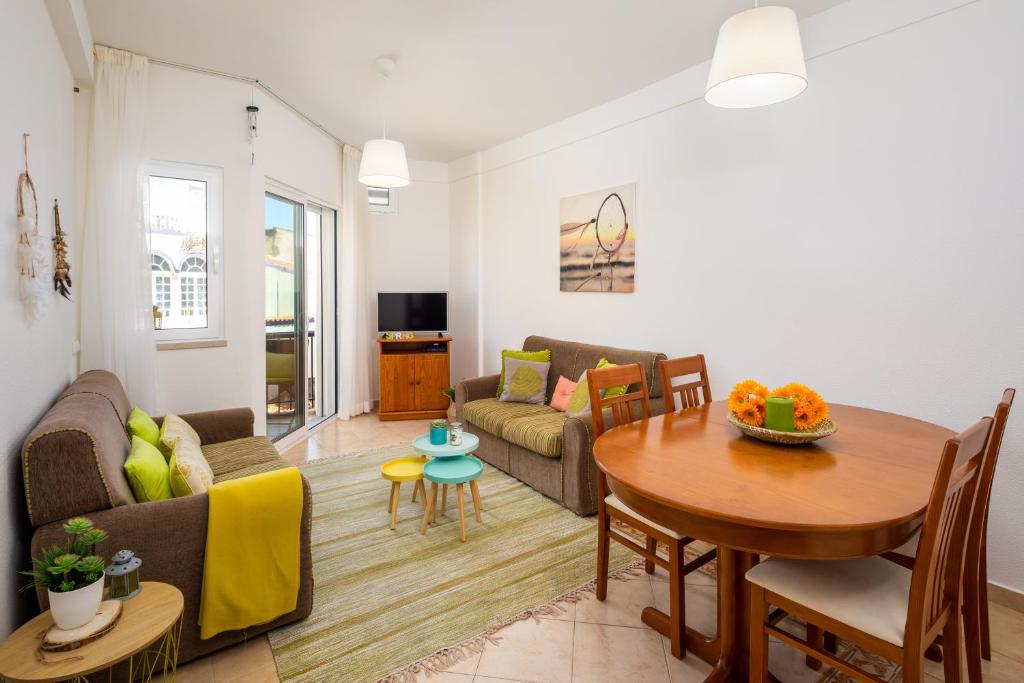 a living room with a table and a couch at Apartamento Pé na Areia, Armação de Pêra in Armação de Pêra