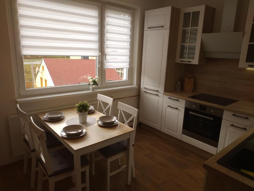 kuchnia ze stołem i krzesłami oraz oknem w obiekcie Apartmán Tereza w mieście Kraslice