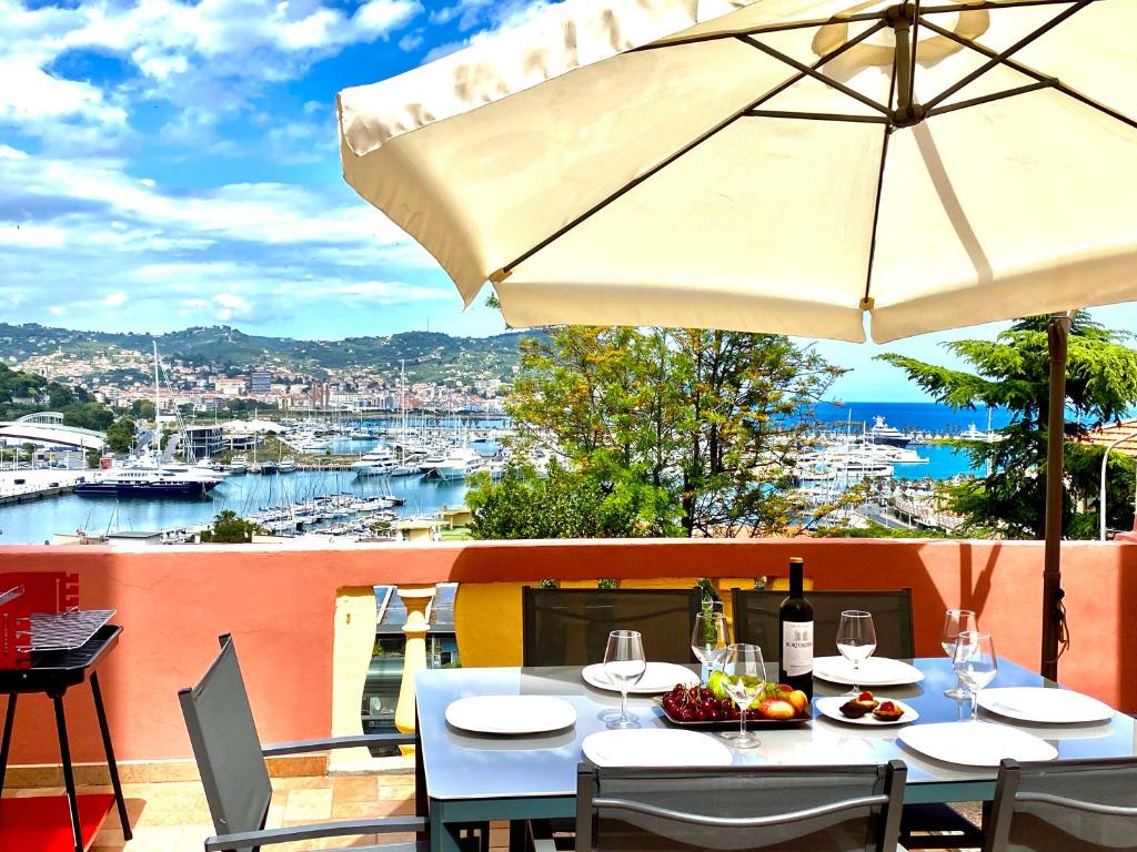 - une table avec des verres à vin et un parasol sur le balcon dans l'établissement ABCdecor Italia, à Imperia