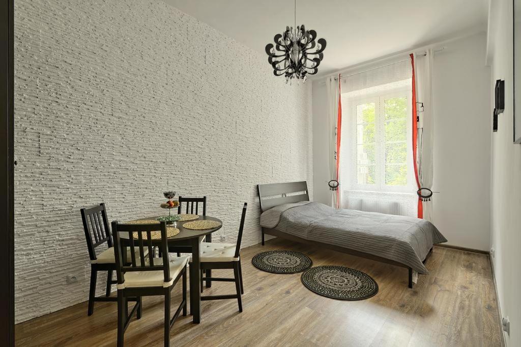 a bedroom with a bed and a table and chairs at Apartament w centrum :) in Krakow